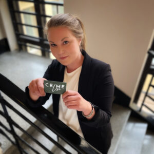 Lakitoimisto Crime Legalin perustajaosakas Emilia Mattila pitelee kädessään Crime Legalin käyntikorttia portaikossa